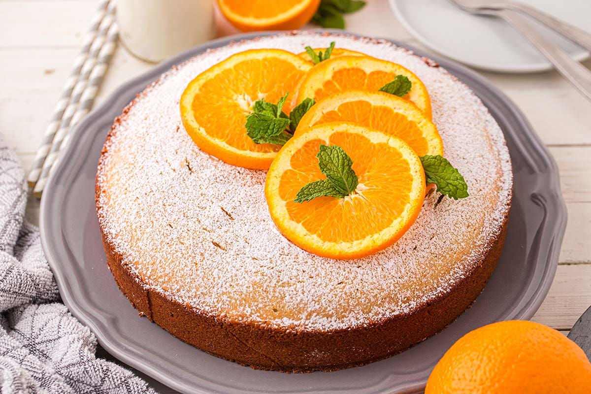 Orange Cake garnished with a couple of orange slices on the plate.