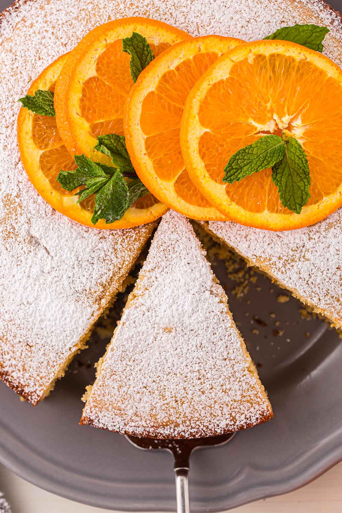 Orange Cake garnished with powdered sugar and orange slices.