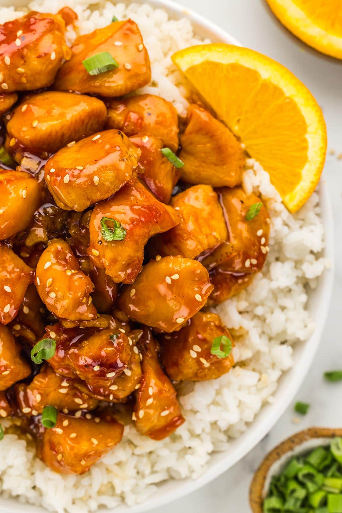 a bowl of rice served with orange chicken. 