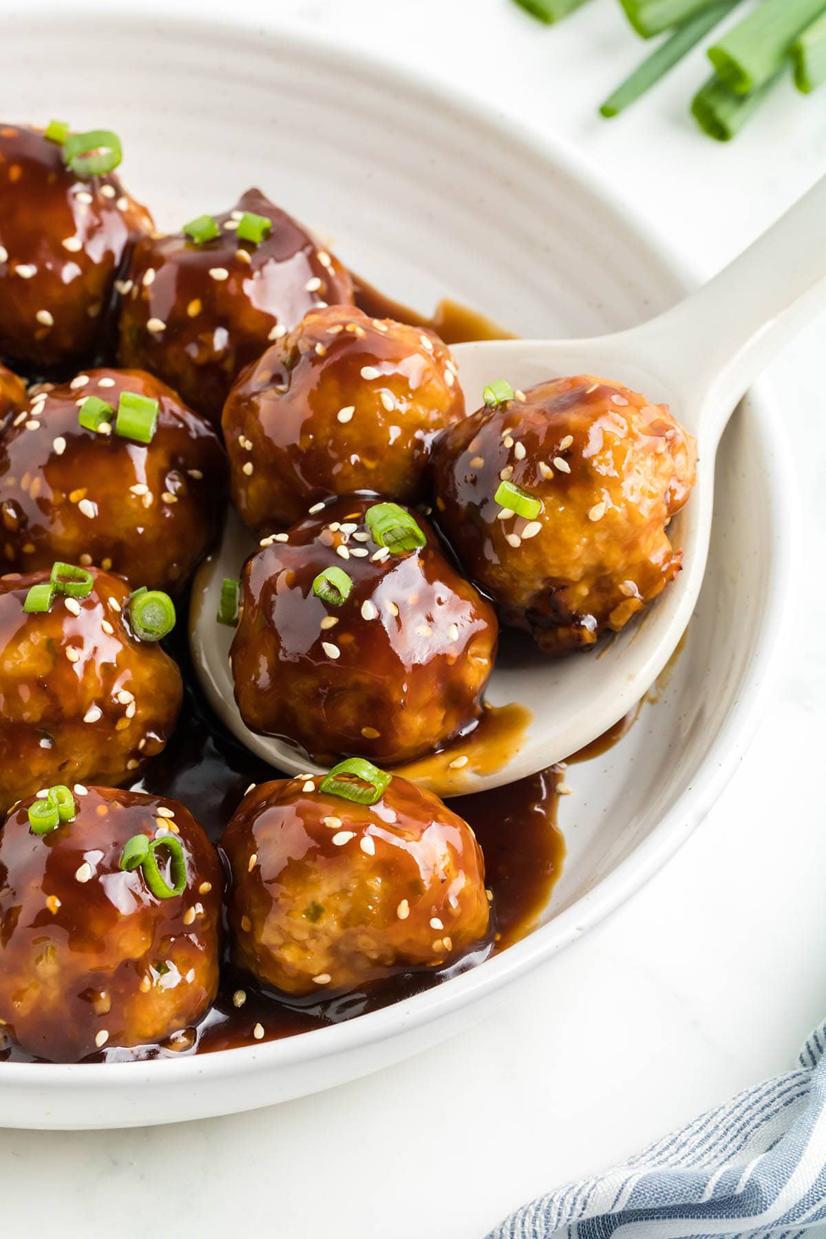 a spoon with 3 pieces of Teriyaki Meatballs.