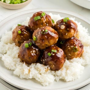 Teriyaki Meatballs served on a plate over rice.