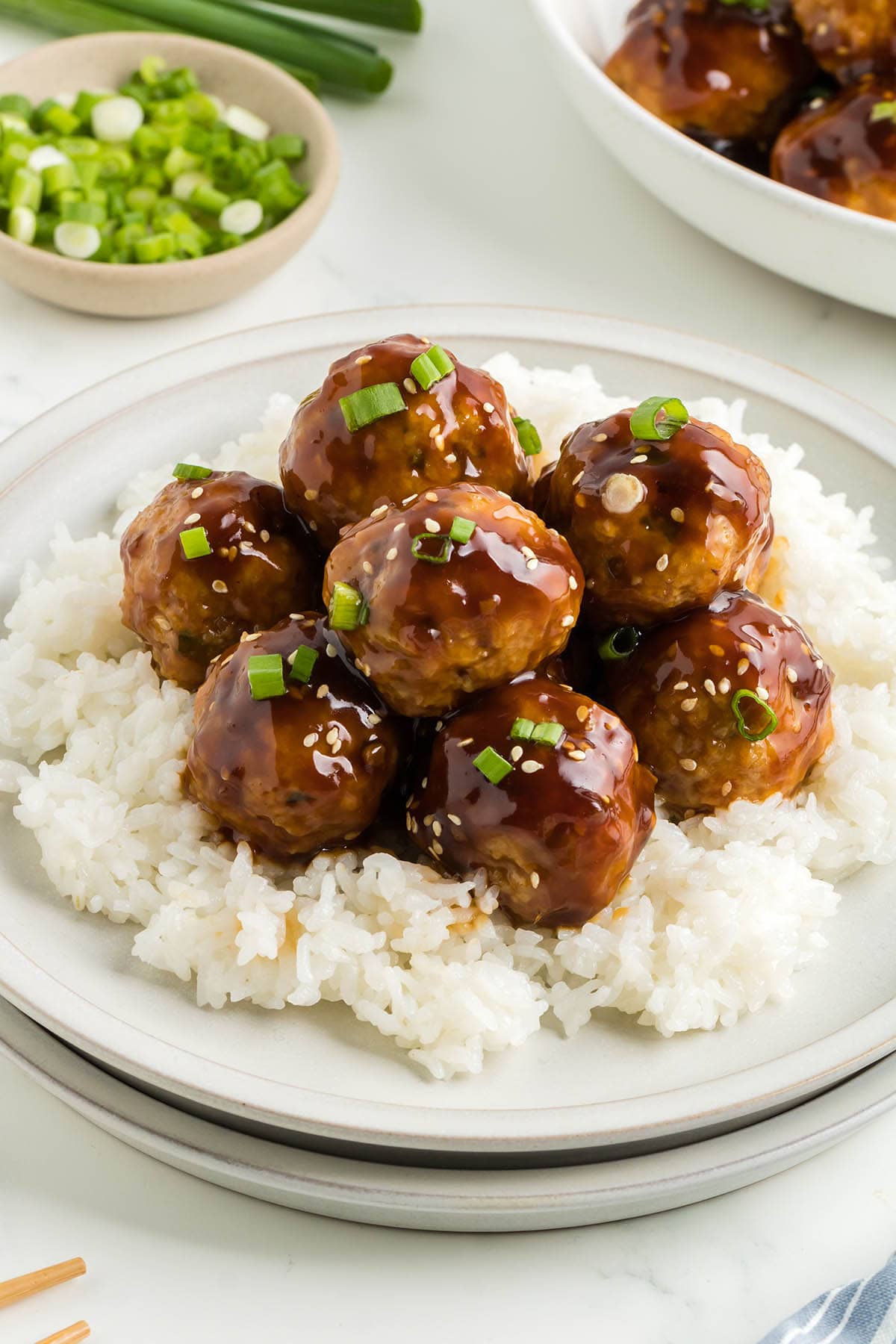 teriyakin meatballs served with rice on a plate.