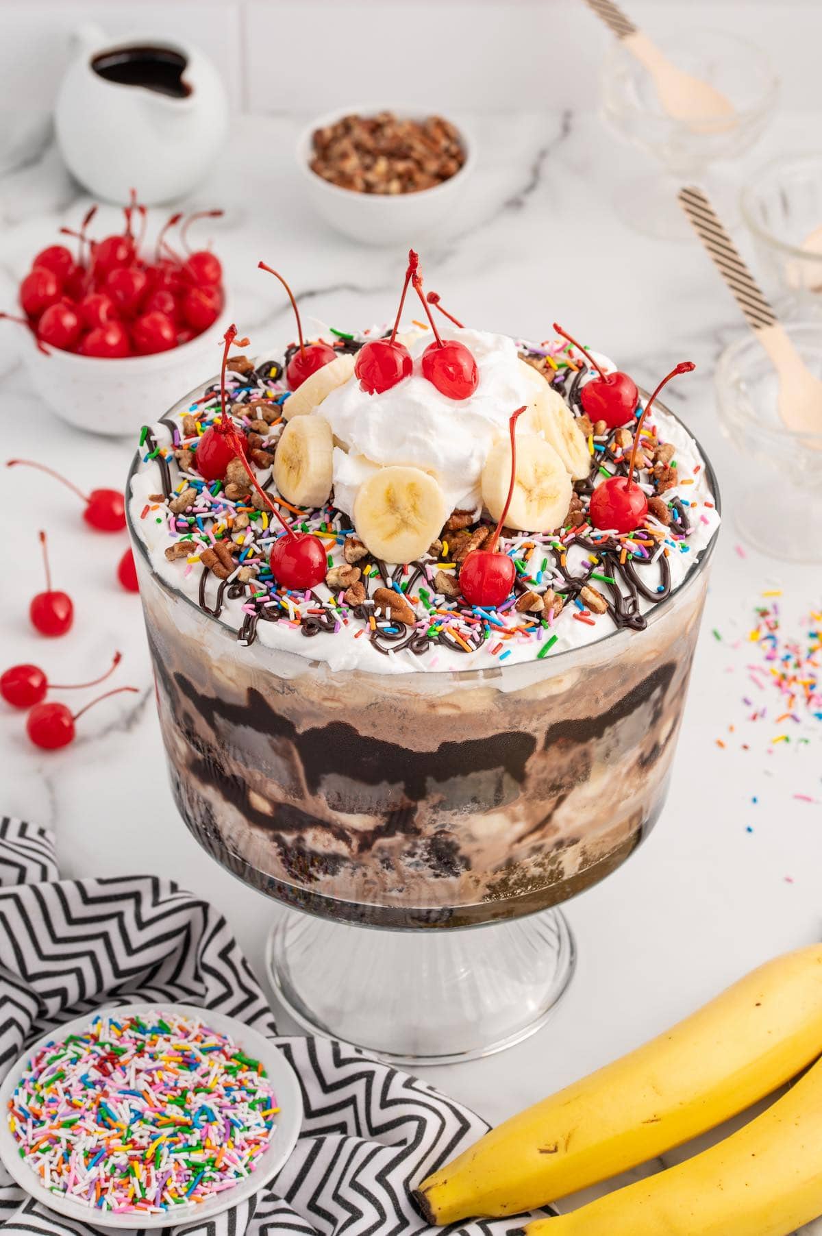 Ice Cream Sundae Trifle on top of the table with sprinkles on the side. 