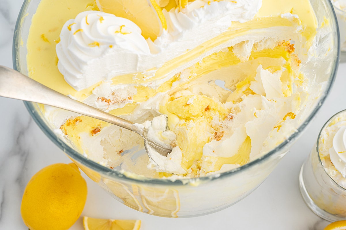 eating Lemon Trifle from a large glass bowl with a spoon.
