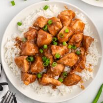 Sweet Hawaiian Crockpot Chicken served with rice on a white plate.