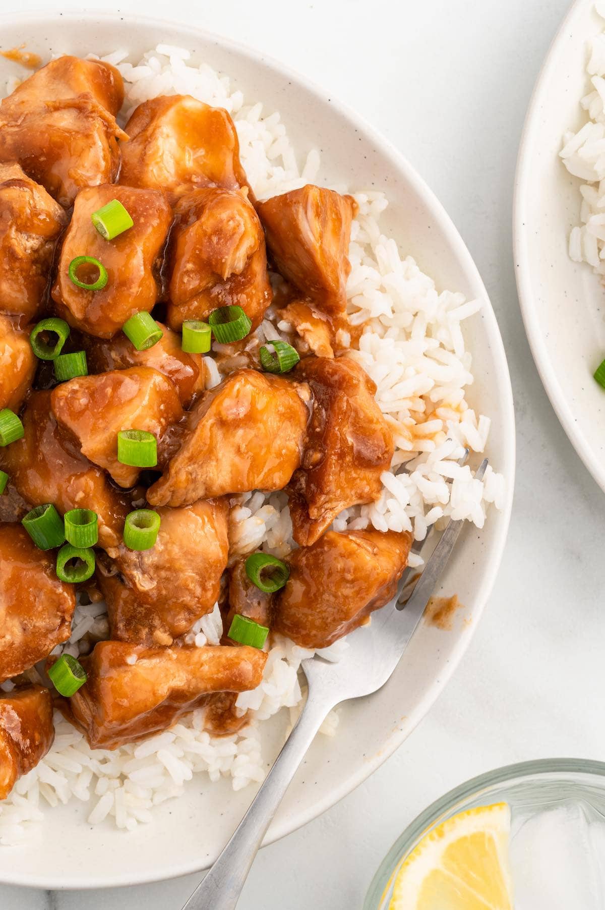 Sweet Hawaiian Crockpot Chicken served over rice and garnished with green onions.