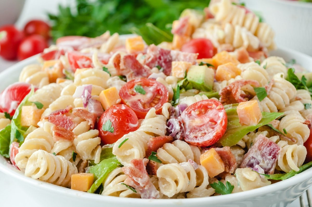 a bowl of blt pasta salad in a white bowl.