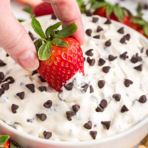 a strawberry dipped in a bowl of Booty Dip with chocolate chips.