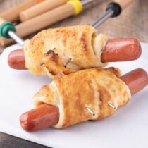 Campfire Crescent Roll Hot Dogs with a skewers.