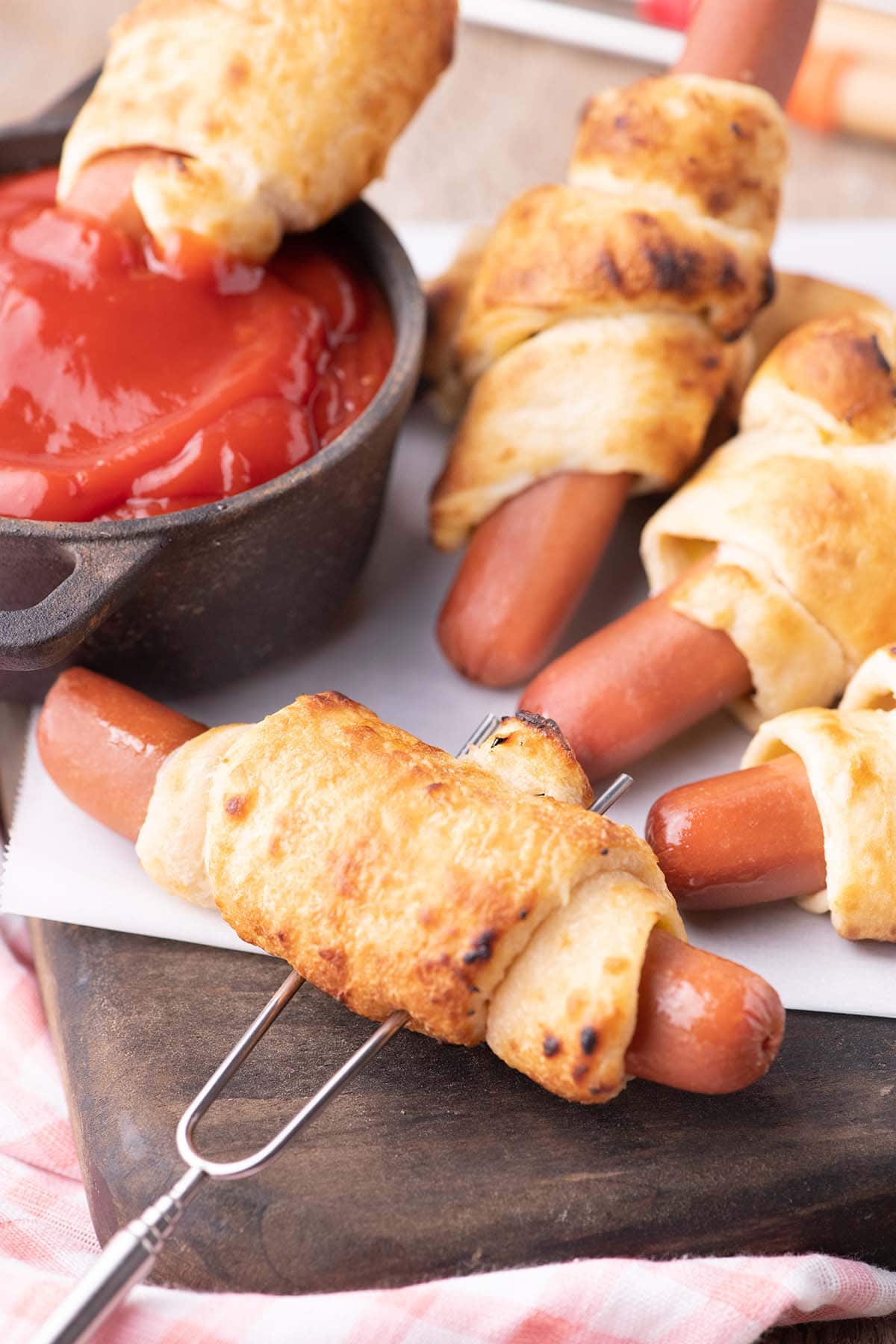 a couple of Campfire Crescent Roll Hot Dogs with ketchup.