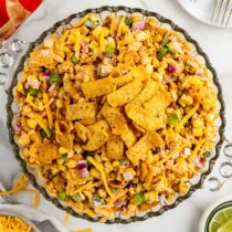 Fritos Corn Salad in a large bowl with corn chips on top.