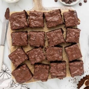 square pieces of boxed brownies on a wooden board.
