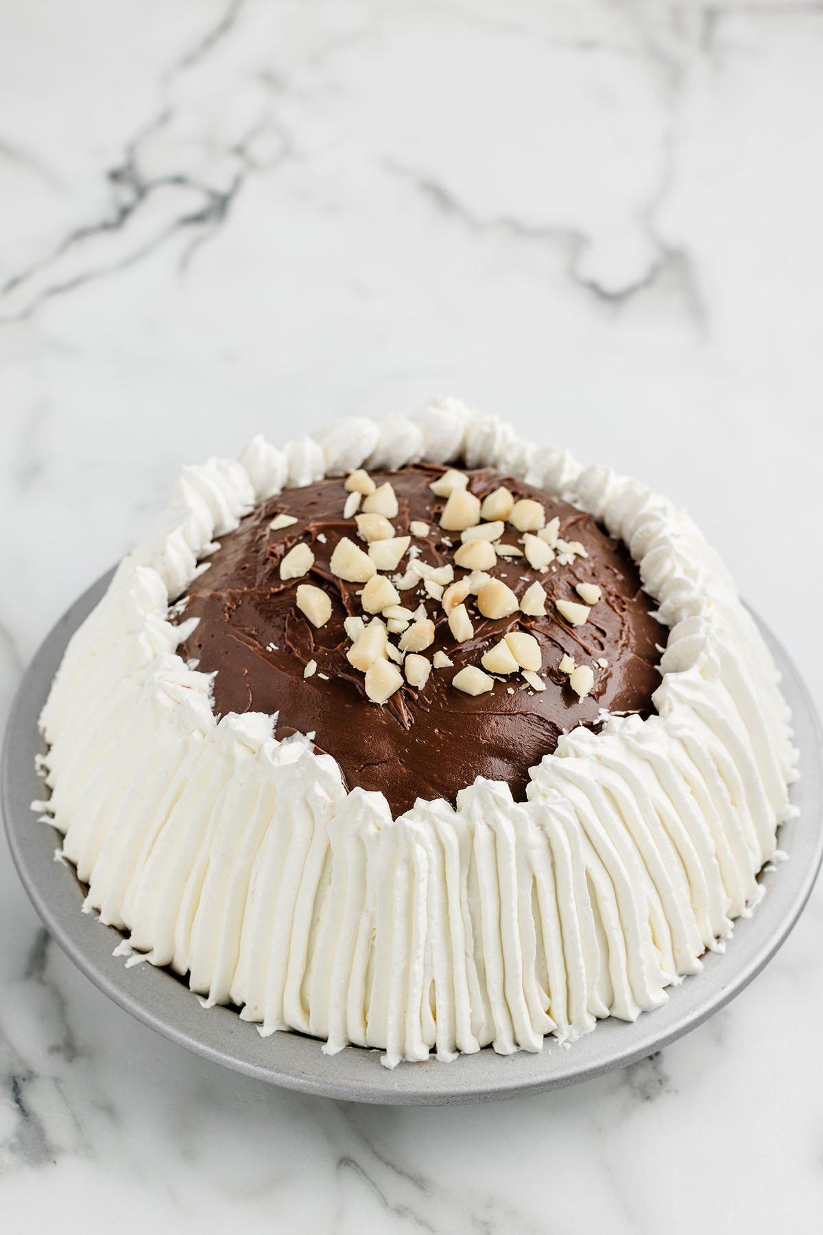 Hula Pie with whipped topping and chopped nuts.