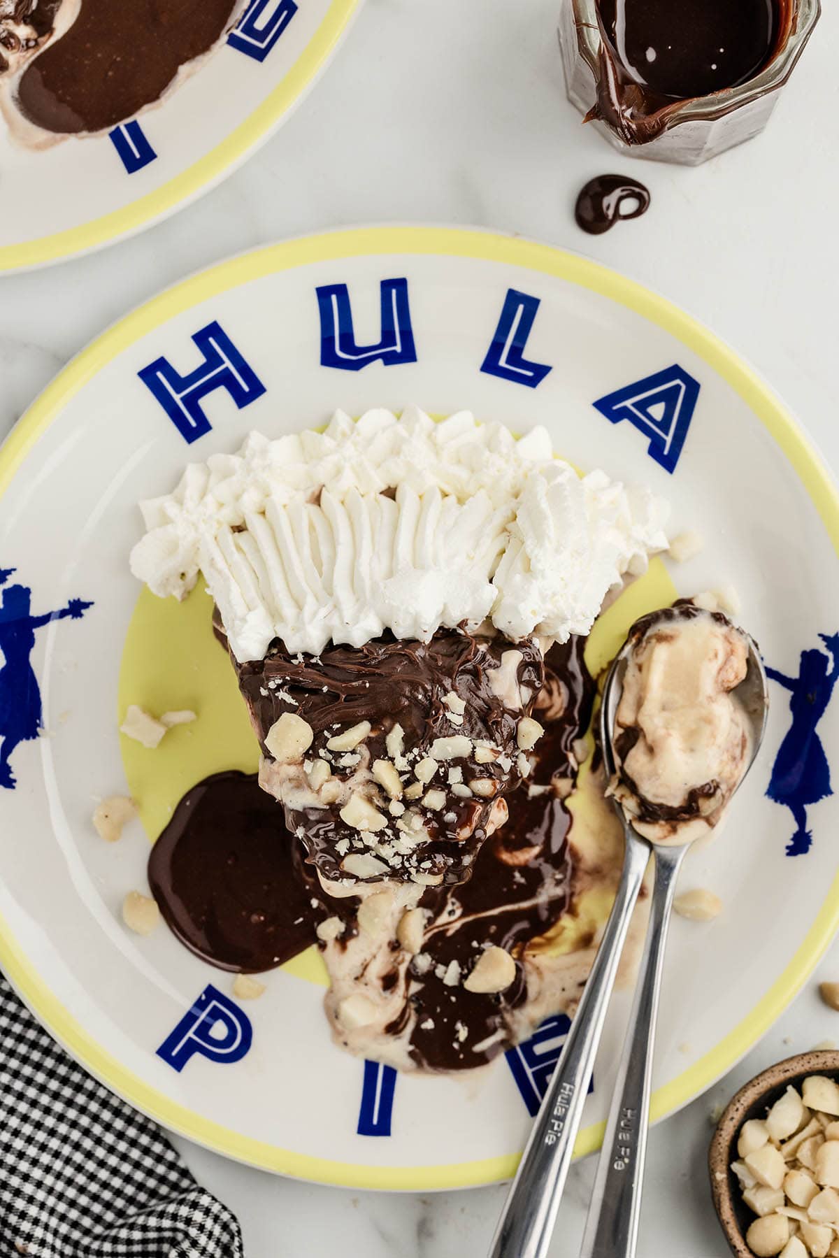 a slice of Hula Pie on the plate garnished with whipped topping and chopped nuts.