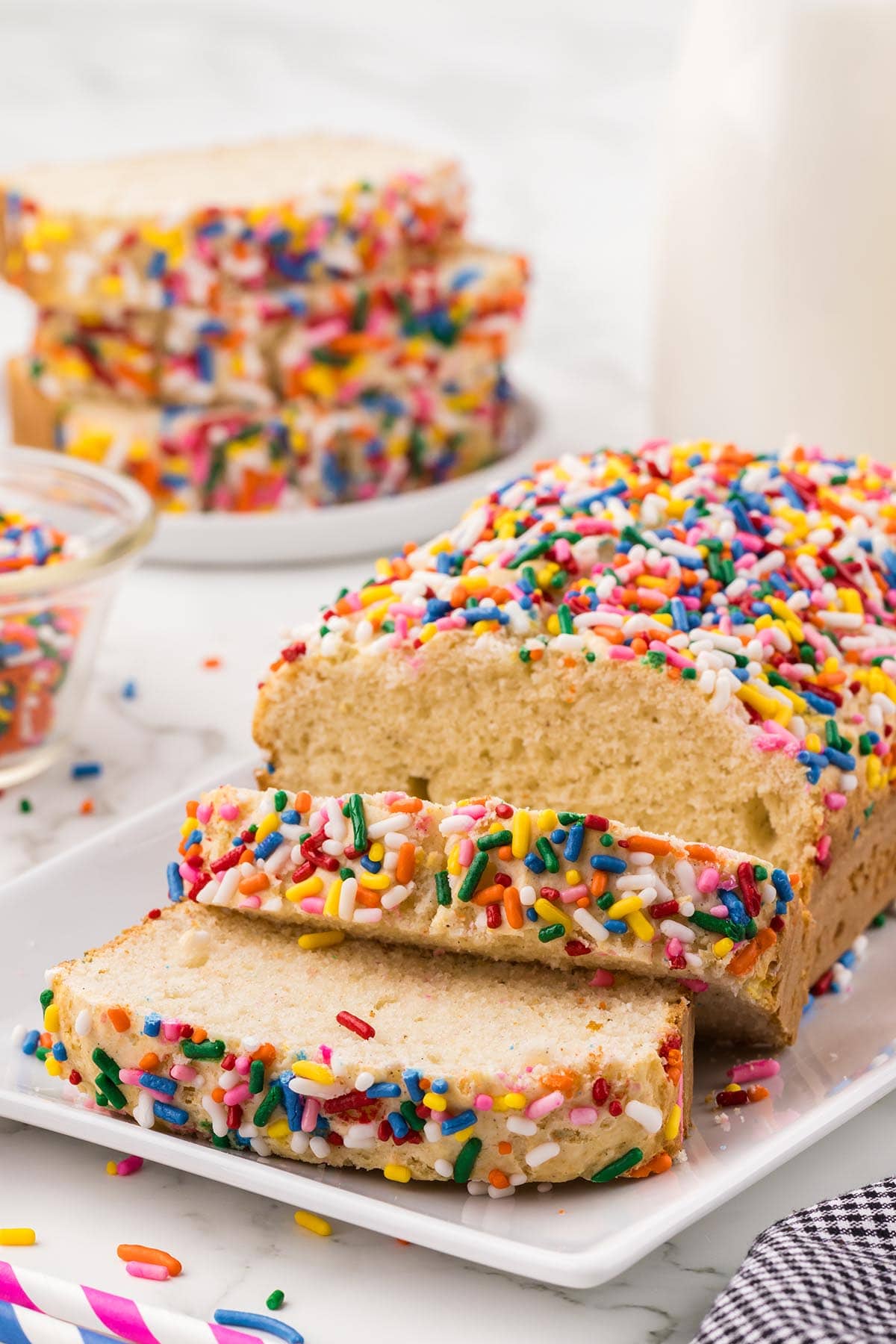 ice cream bread with lots of sprinkle sliced on a plate.