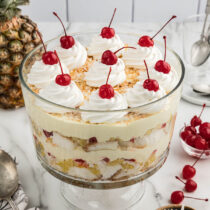 5 layer of Pina Colada Trifle with a dollop of cool whip and cherries on top.
