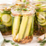 a couple of Dill Pickles in a jar.