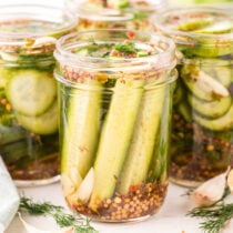 a couple of Dill Pickles in a jar.
