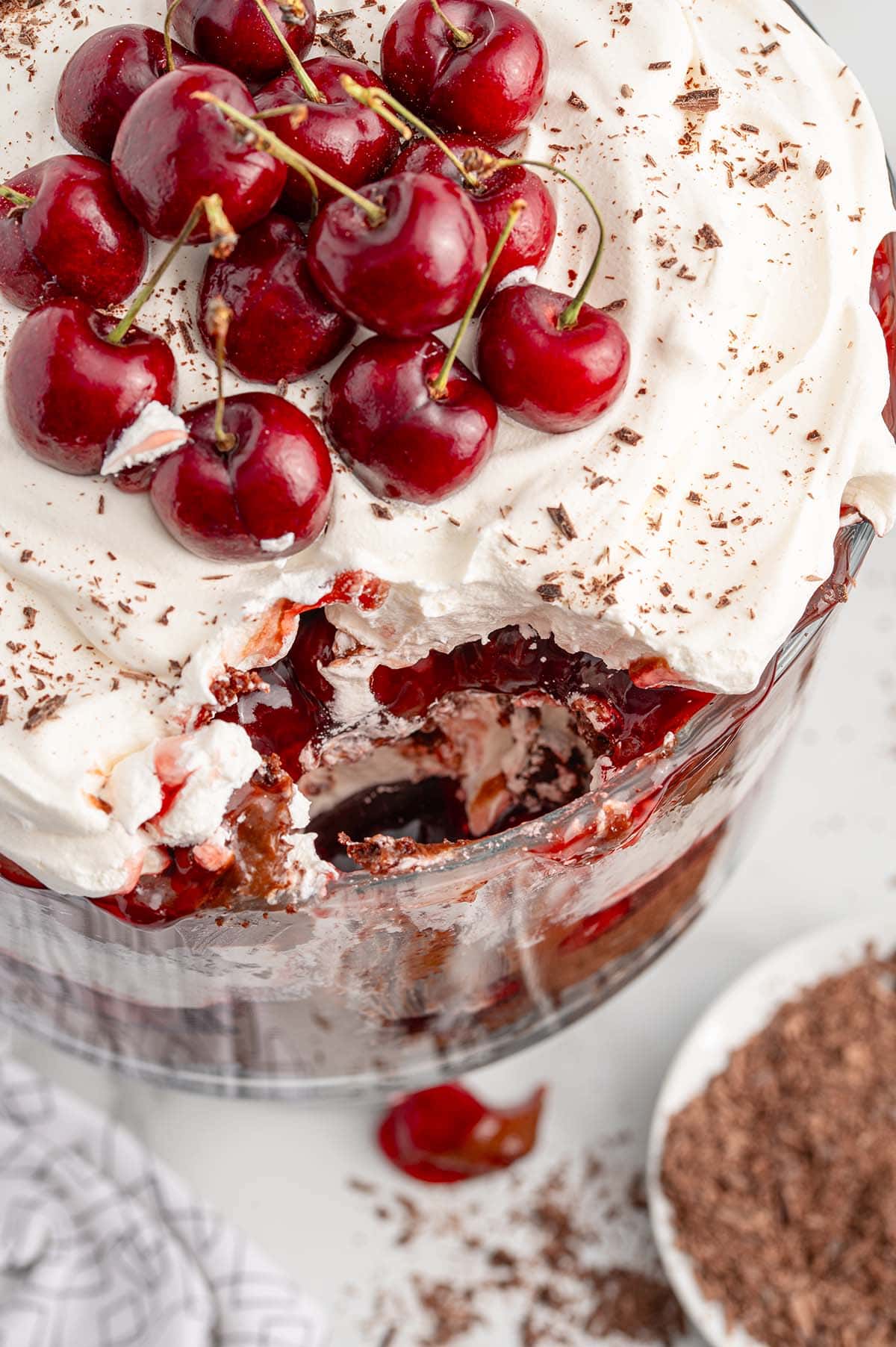 Black Forest Trifle in a trifle container topped with cherries.