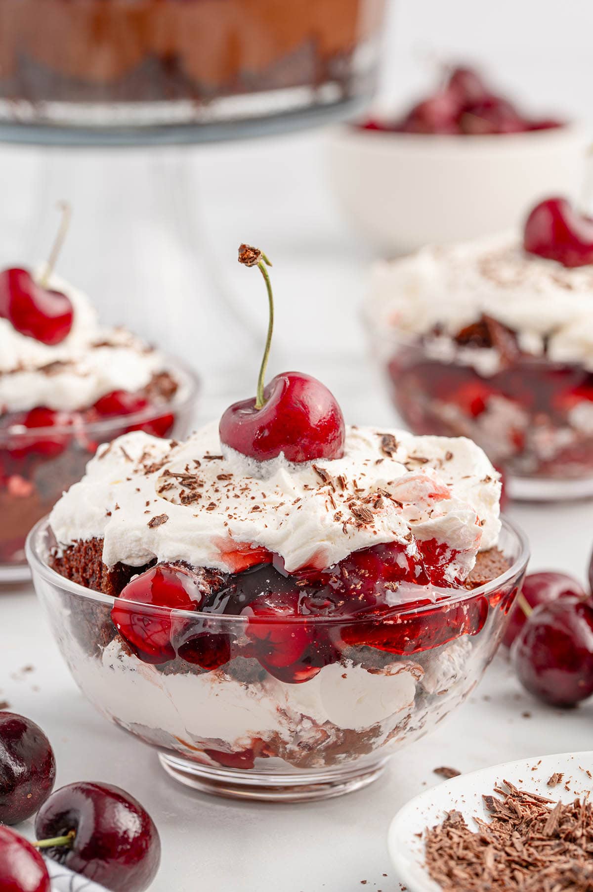 Black Forest Trifle in a dessert glass topped with whipped topping and cherry.