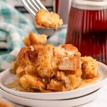 a plate of Crockpot French Toast Casserole with a pitcher of tea in the background.