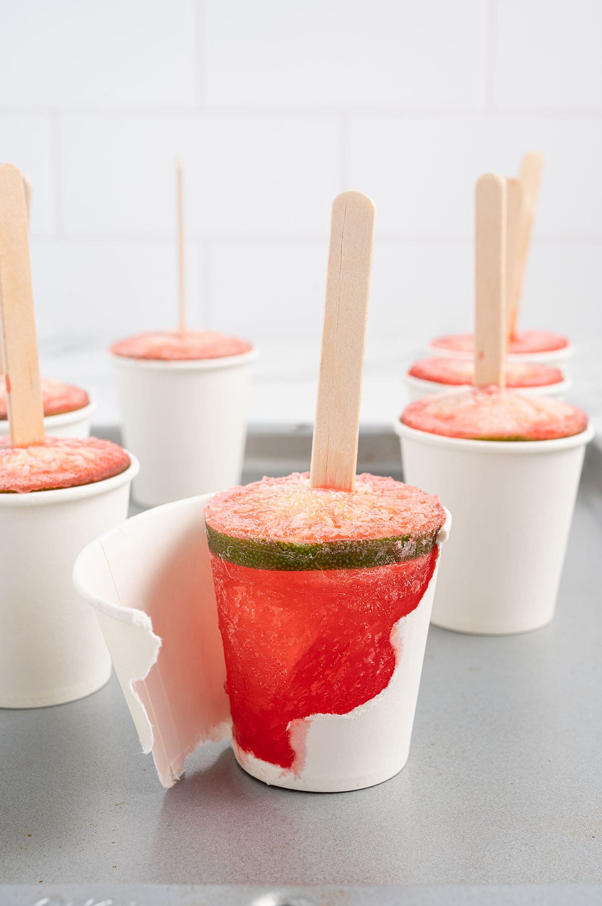 a couple of Dirty Shirley Popsicle inside paper cups on the table.