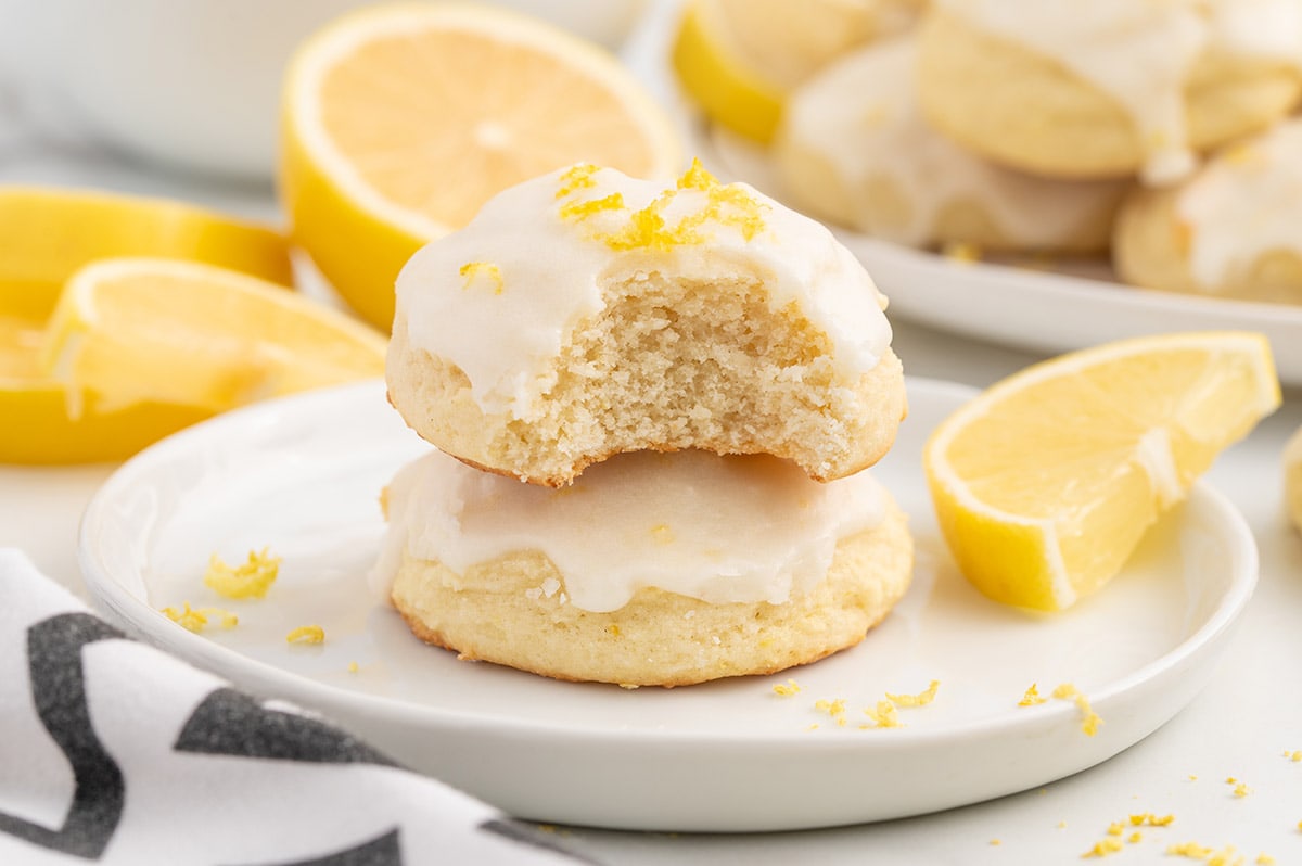 bitten and stacked lemon ricotta cookies on a plate.
