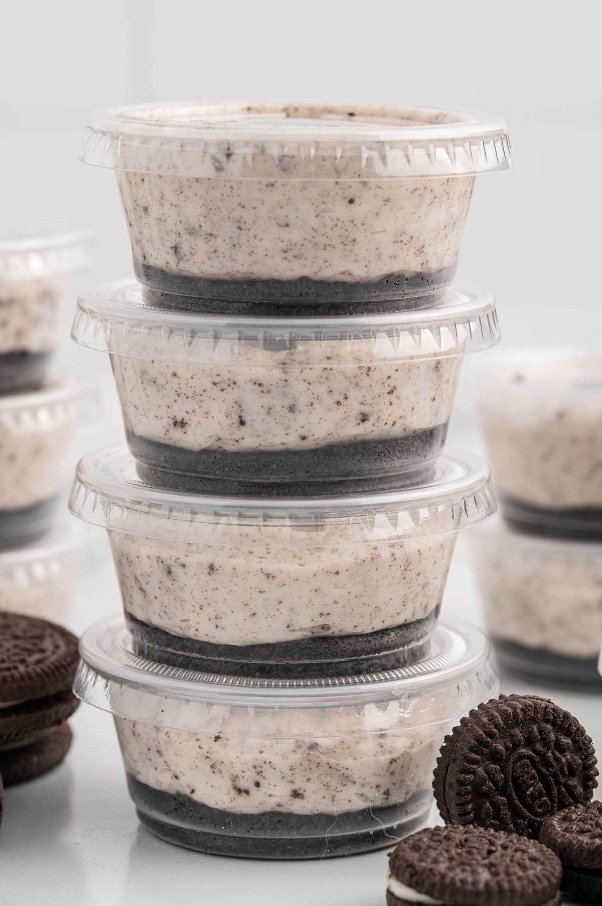 Oreo Dessert Cups with lids on stacked up on top of table.