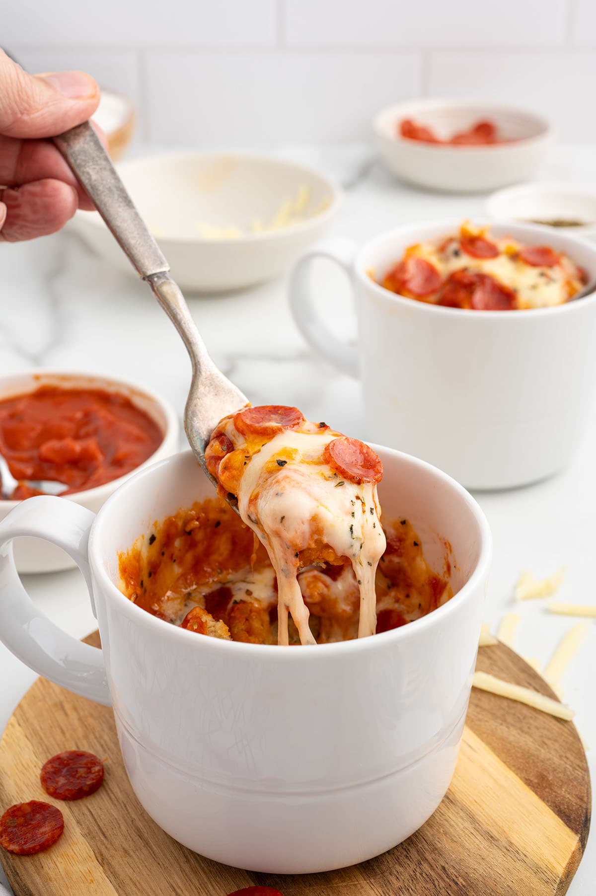 eating Pizza in a Mug using a fork with melted cheese.