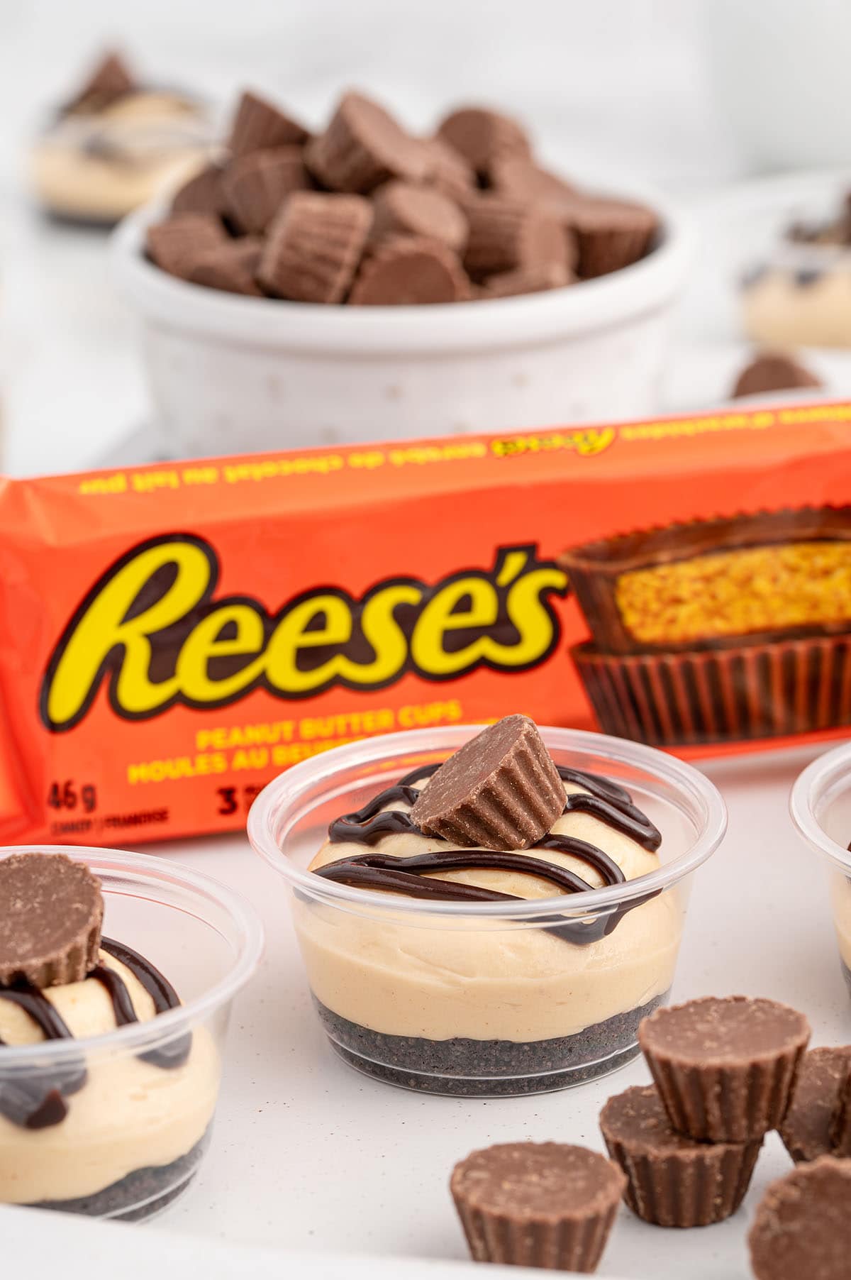 a couple of Chocolate Peanut Butter Dessert Cups with Reese’s peanut butter cups package on the background.