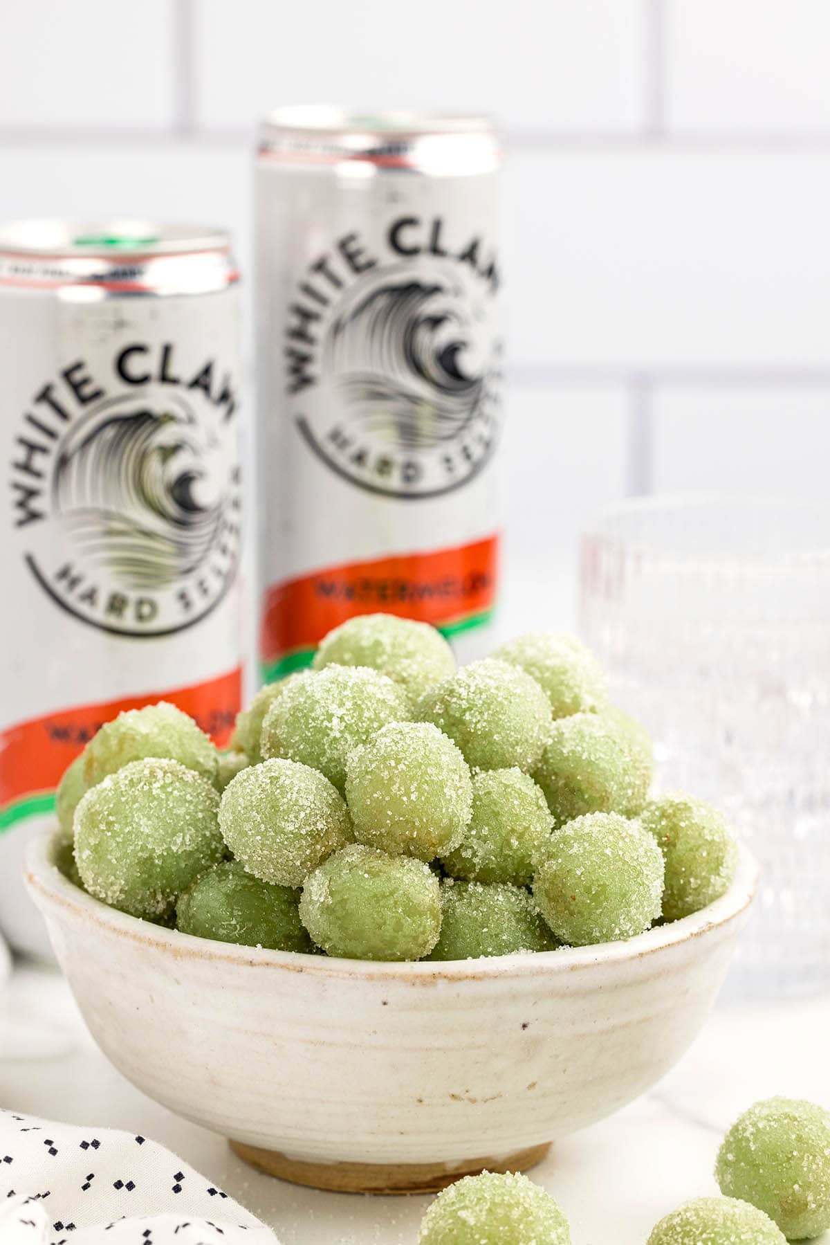 a bowl of Boozy Grapes and two cans of white claws.