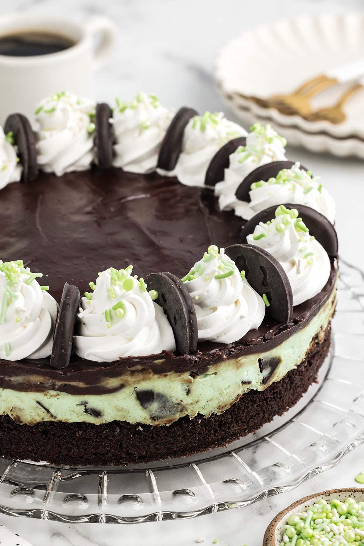 a Thin Mint Cheesecake on the table with cookies and whipped topping on top.