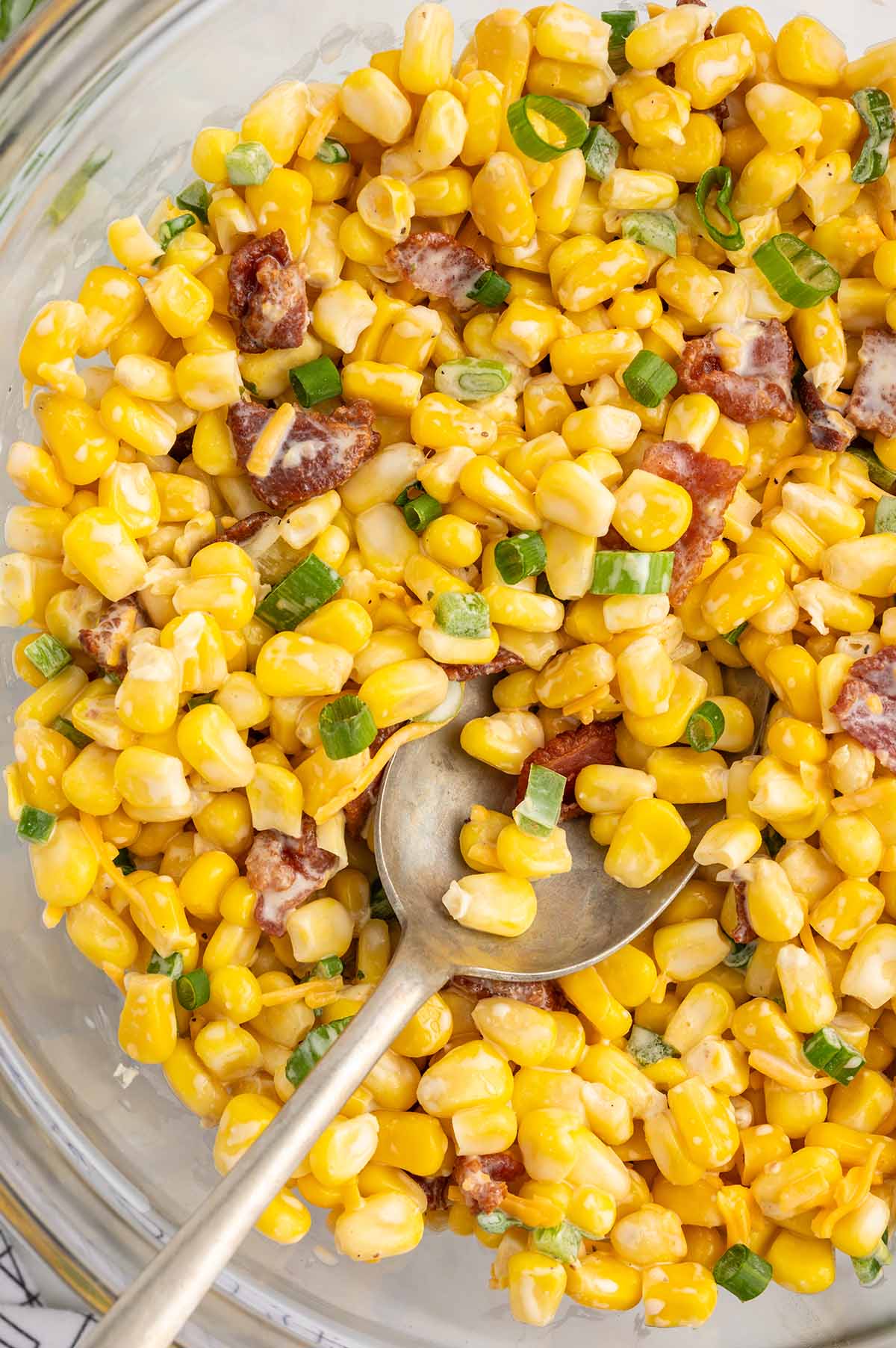 Crack Corn Salad in a large bowl garnished with sliced onions.