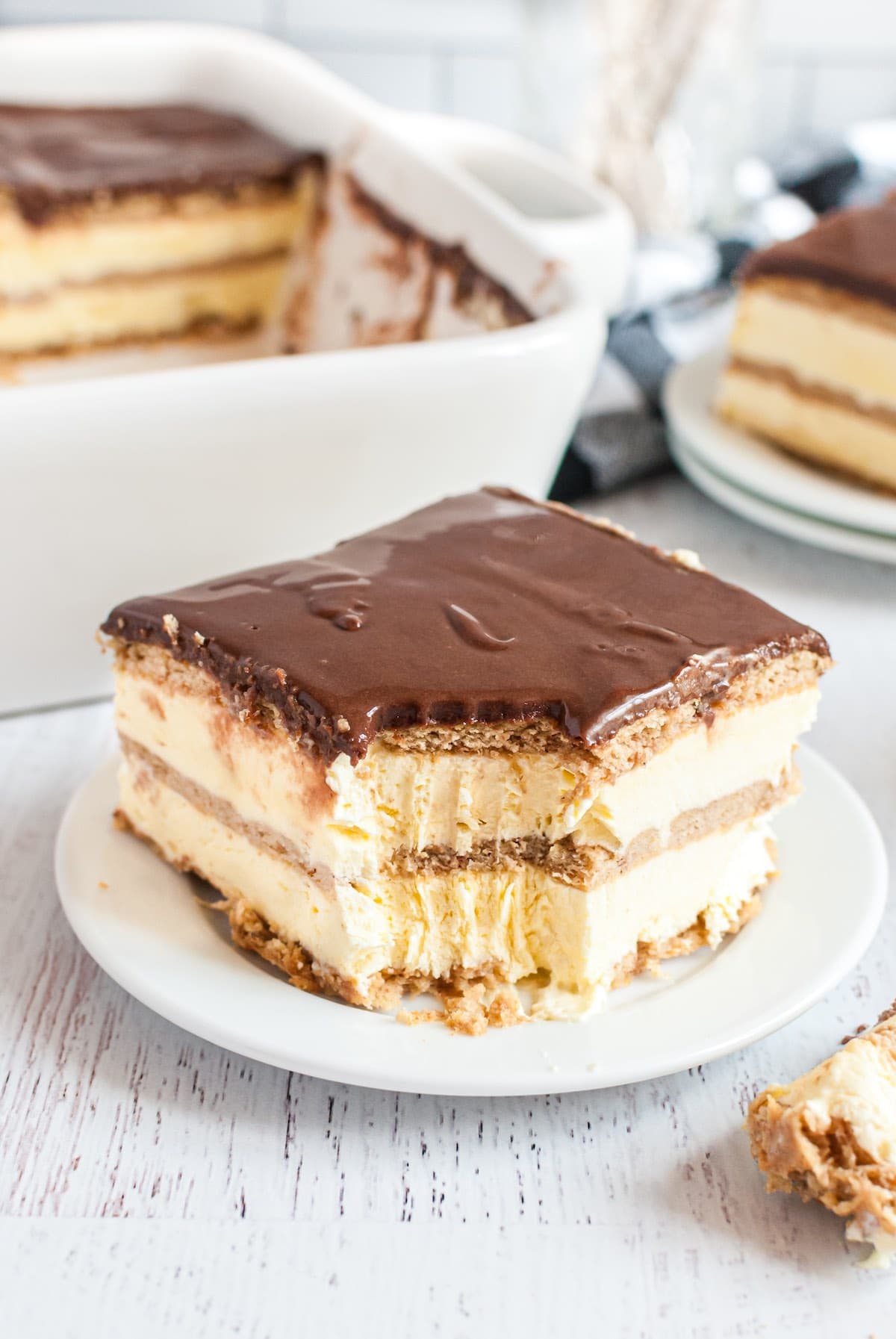 a slice of bitten eclair cake on a plate. 