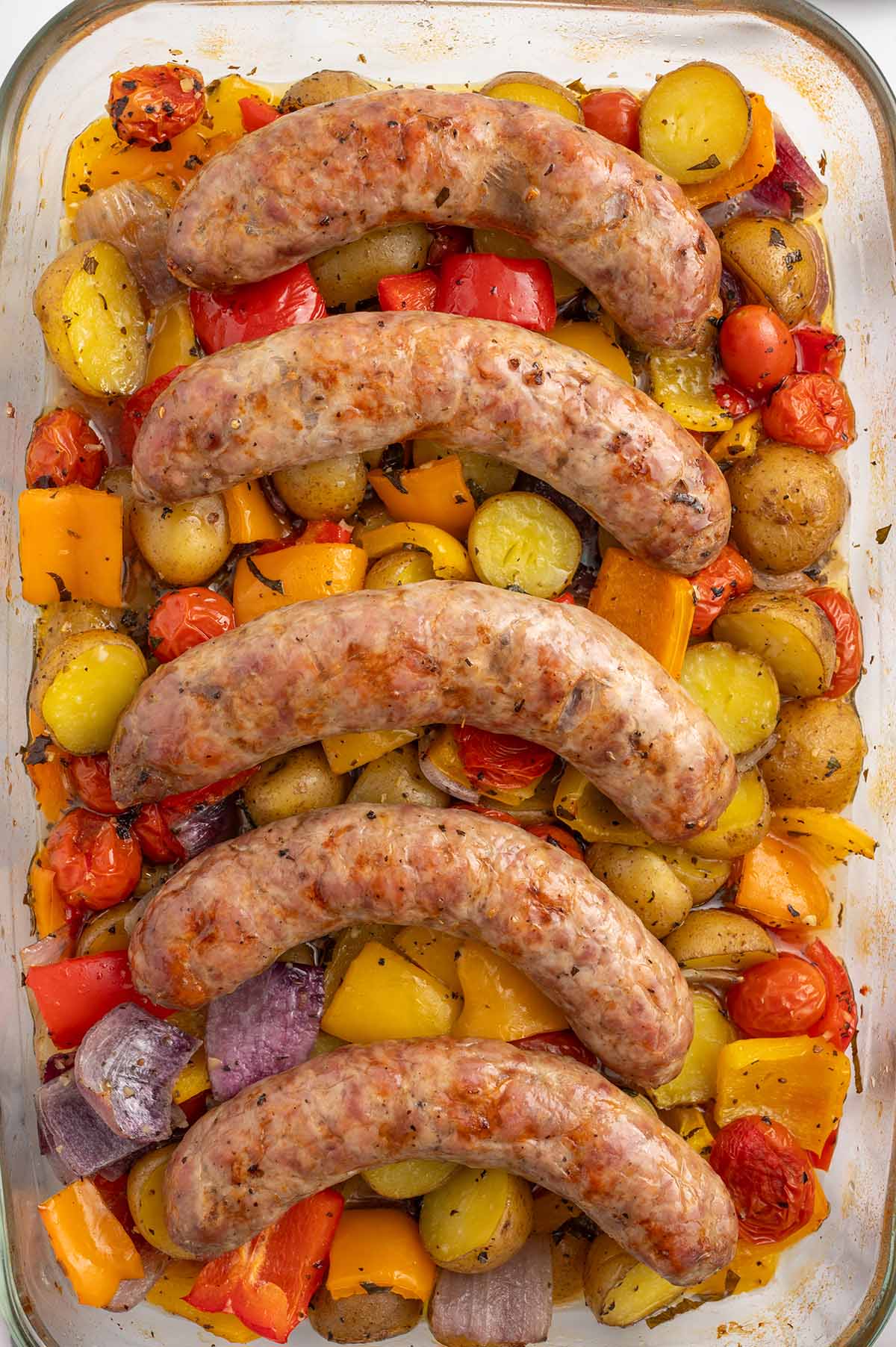 Baked Italian Sausage lined up in a baking dish.