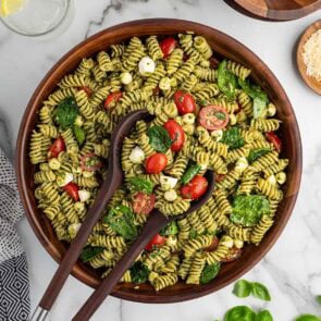 pesto pasta salad in a wooden bowl.