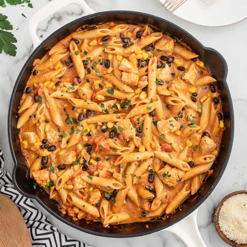 A skillet of Southwest Chicken Pasta garnished with parsley.