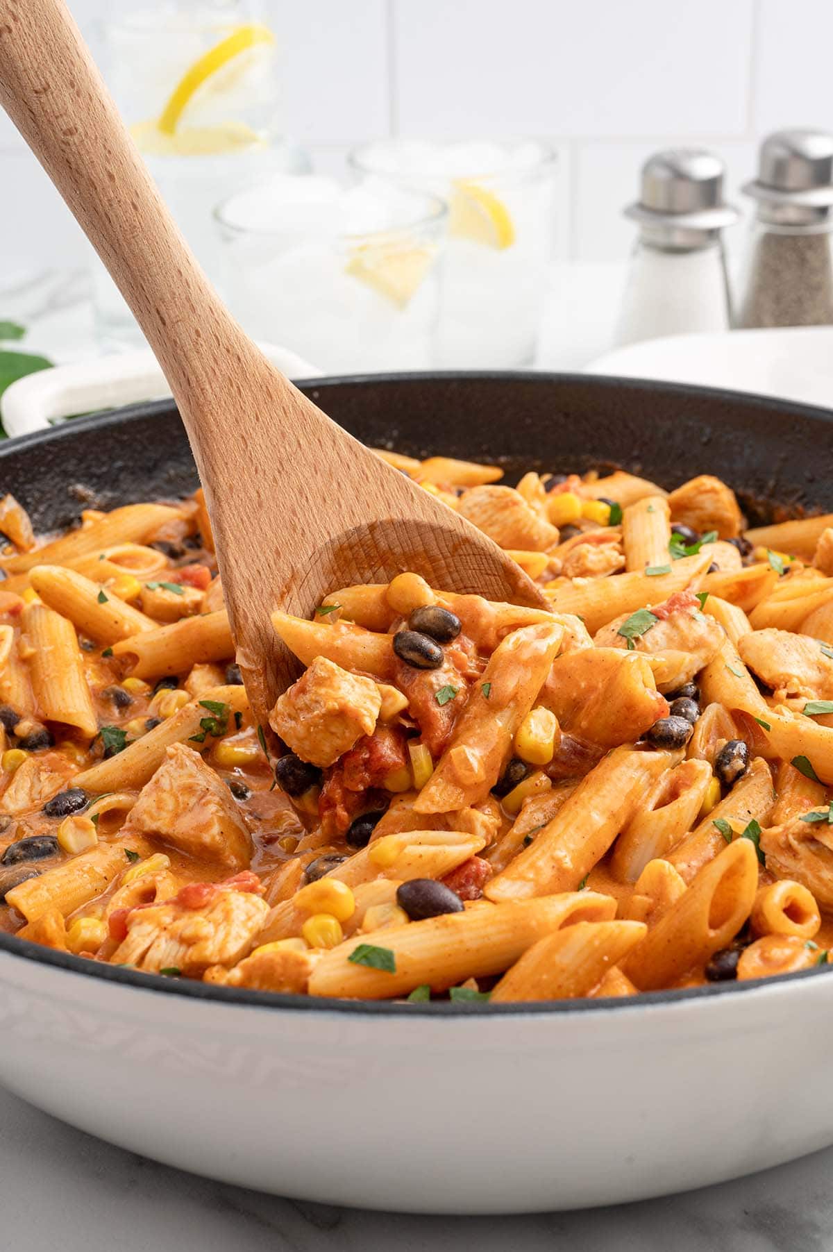 Southwest Chicken Pasta in a large skillet with wooden spoon.