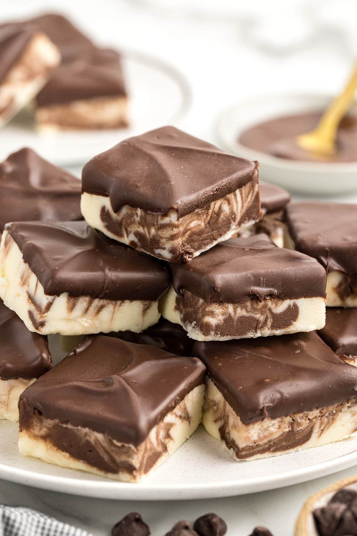 a couple of Boston Cream Fudge covered with melted chocolate stacked on a plate. 