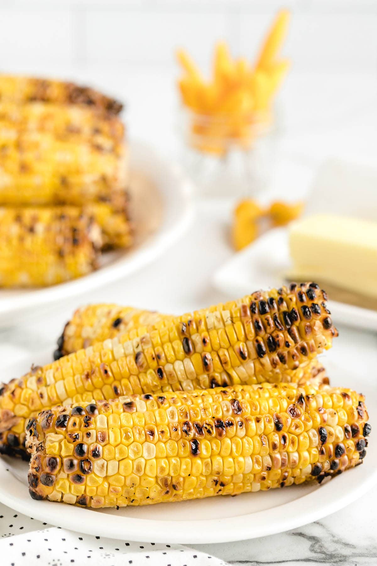bbq corn on the cob placed on a plate. 