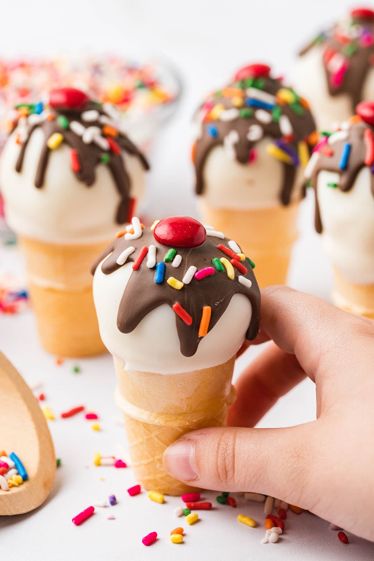 hand holding ice cream cone cake pops. 