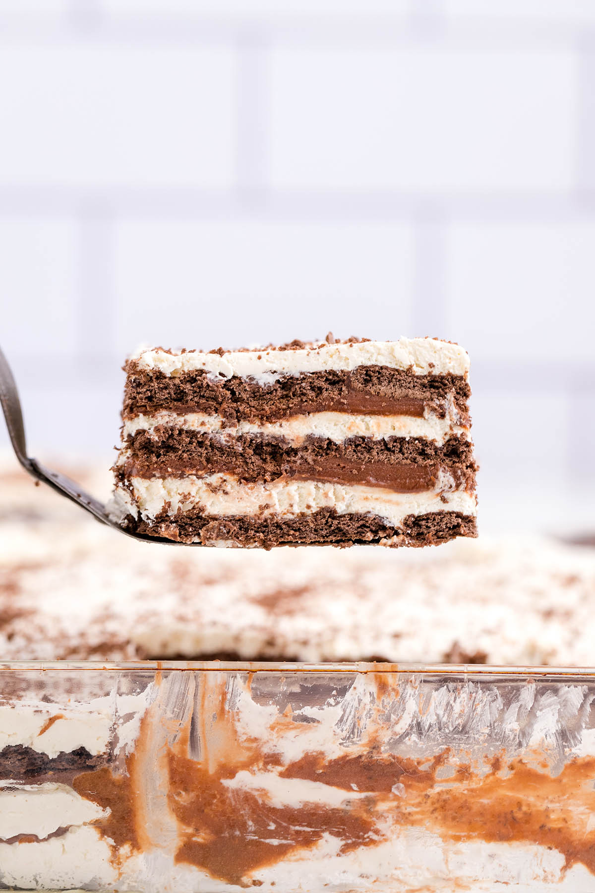 taking a square piece of icebox cake from the casserole dish. 