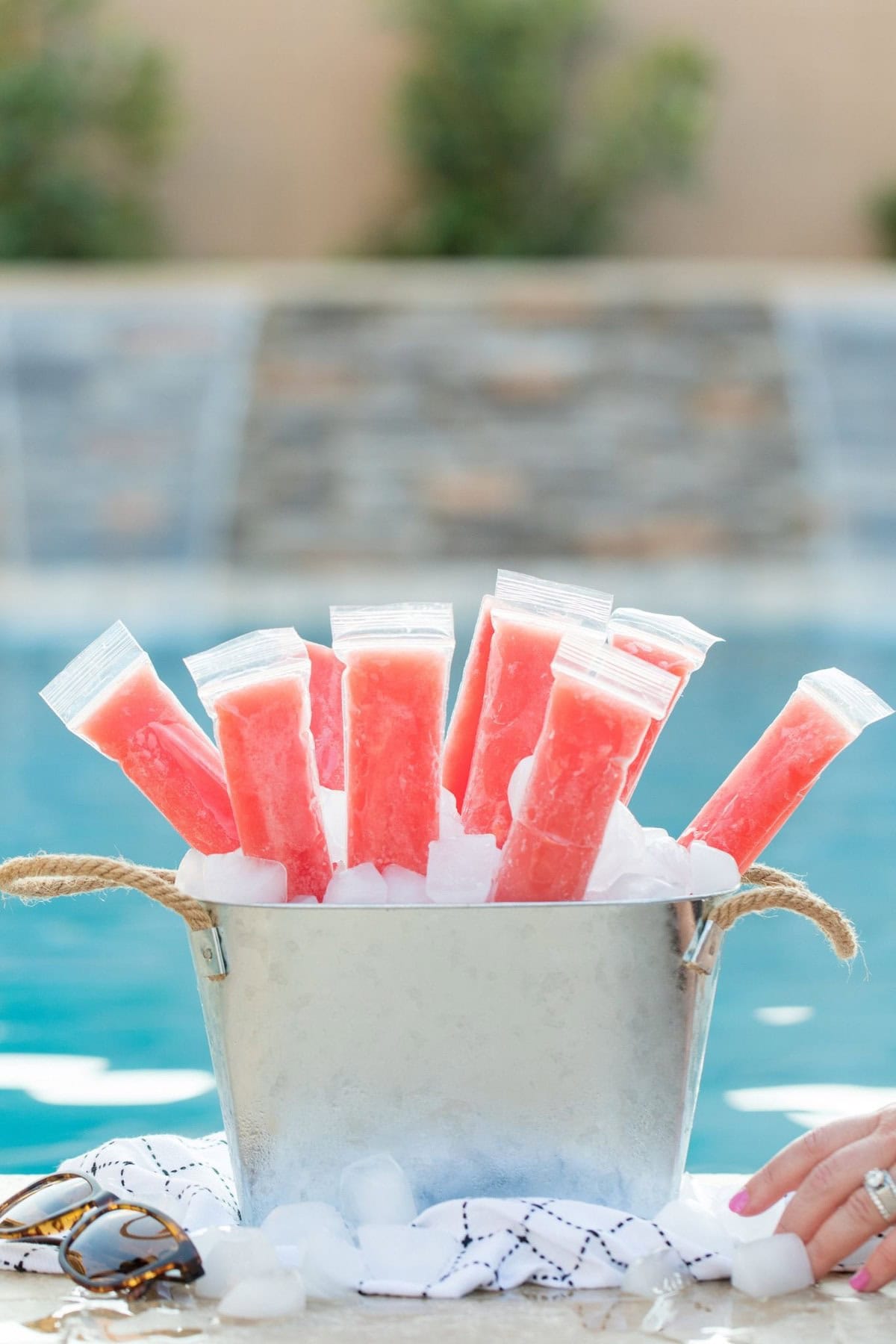 watermelon boozy popsicle inside big bucket filled with ice. 