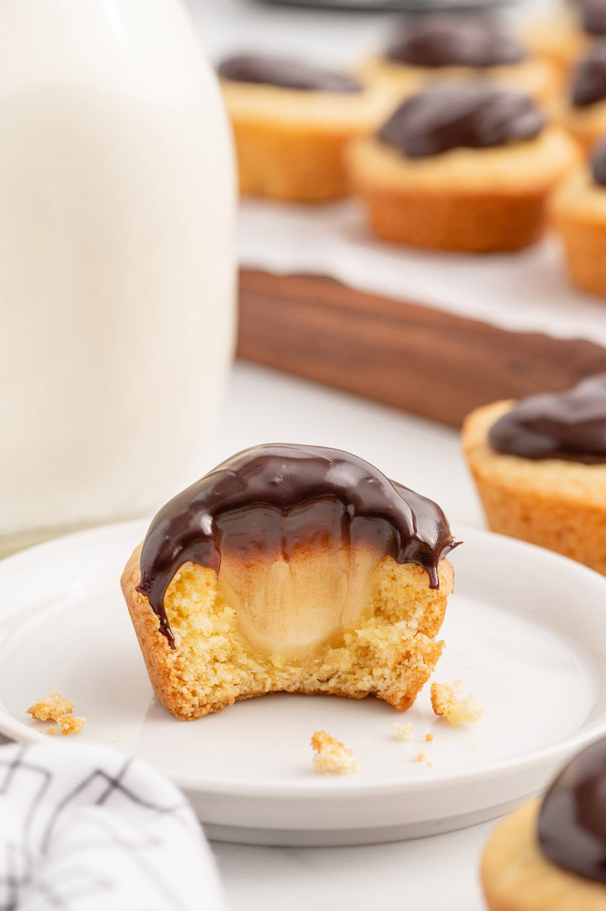 bitten Boston Cream Pie Cookie Cup topped with chocolate ganache.