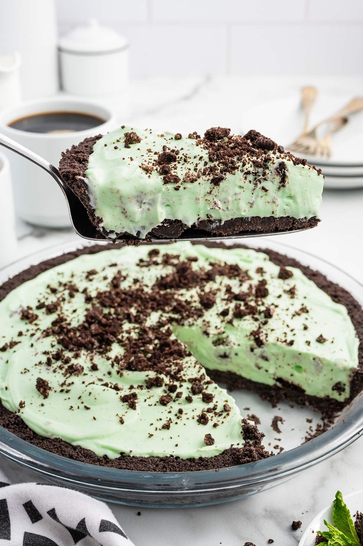 a slice of Mint Chocolate Pie being lifted from the whole pie using a spatula.