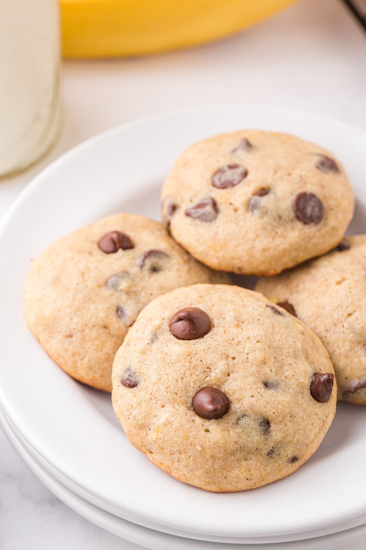 a couple of Banana Bread Cookies on a white plate with chocolate chips.