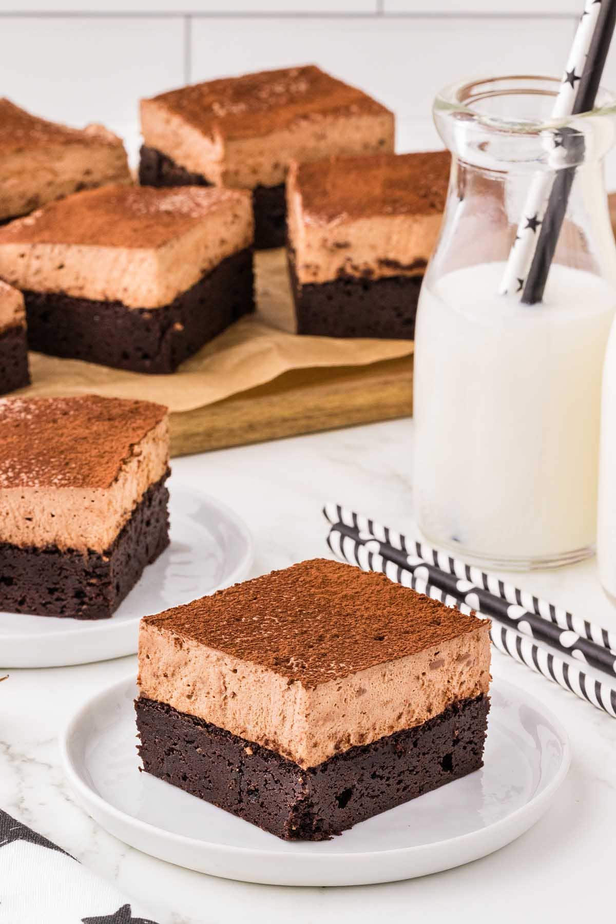 a square piece of Chocolate Mousse Brownies with a bottle of milk and straws in the background.