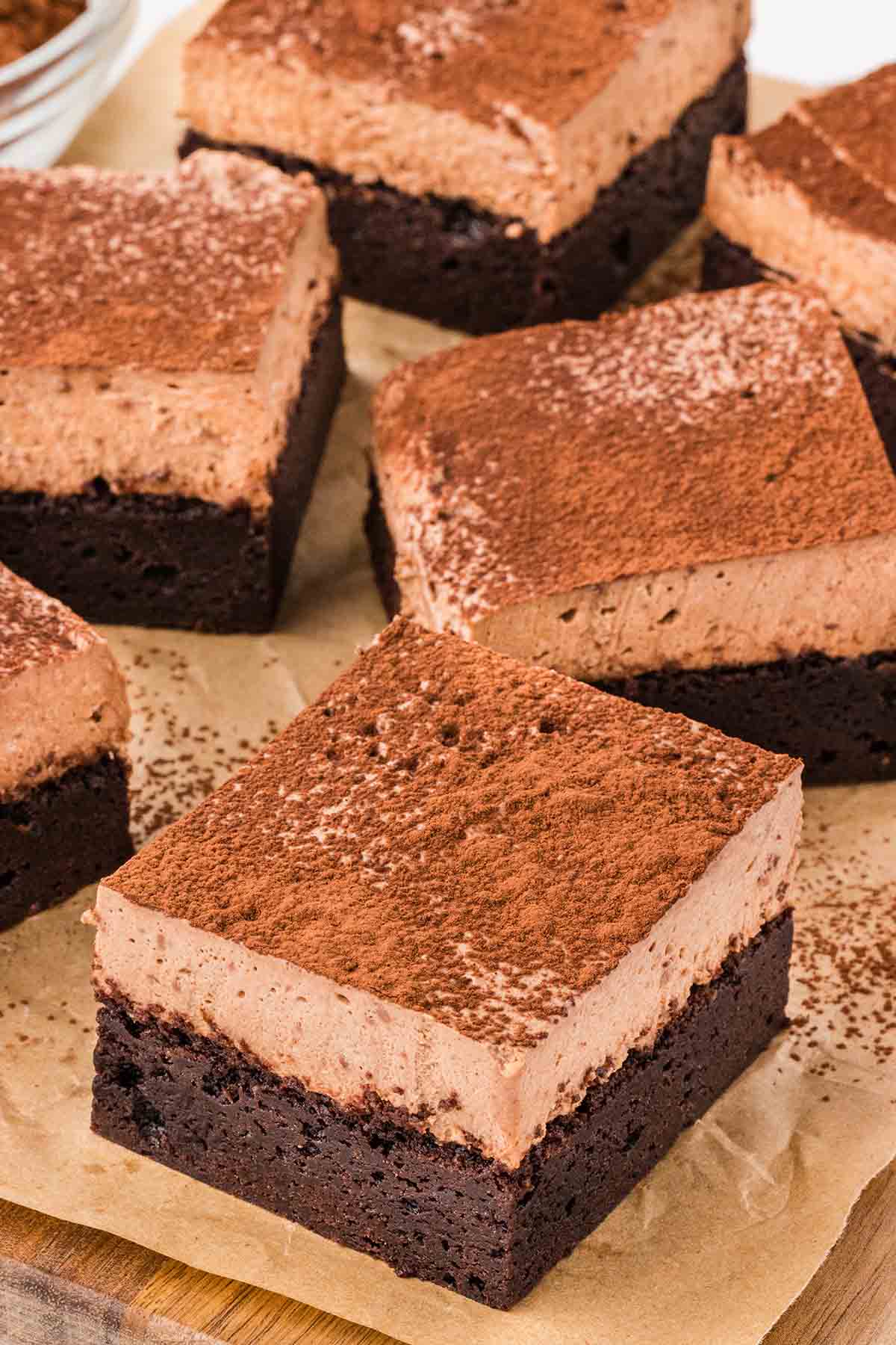 a couple of Chocolate Mousse Brownies with a layer of chocolate cake dusted with cocoa powder.