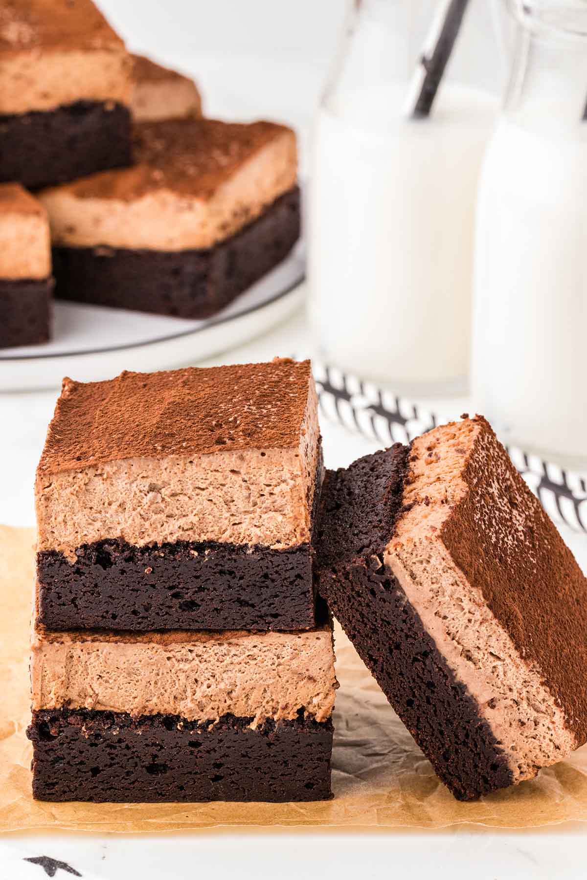 three pieces of chocolate mousse brownie stacked on top of table. 