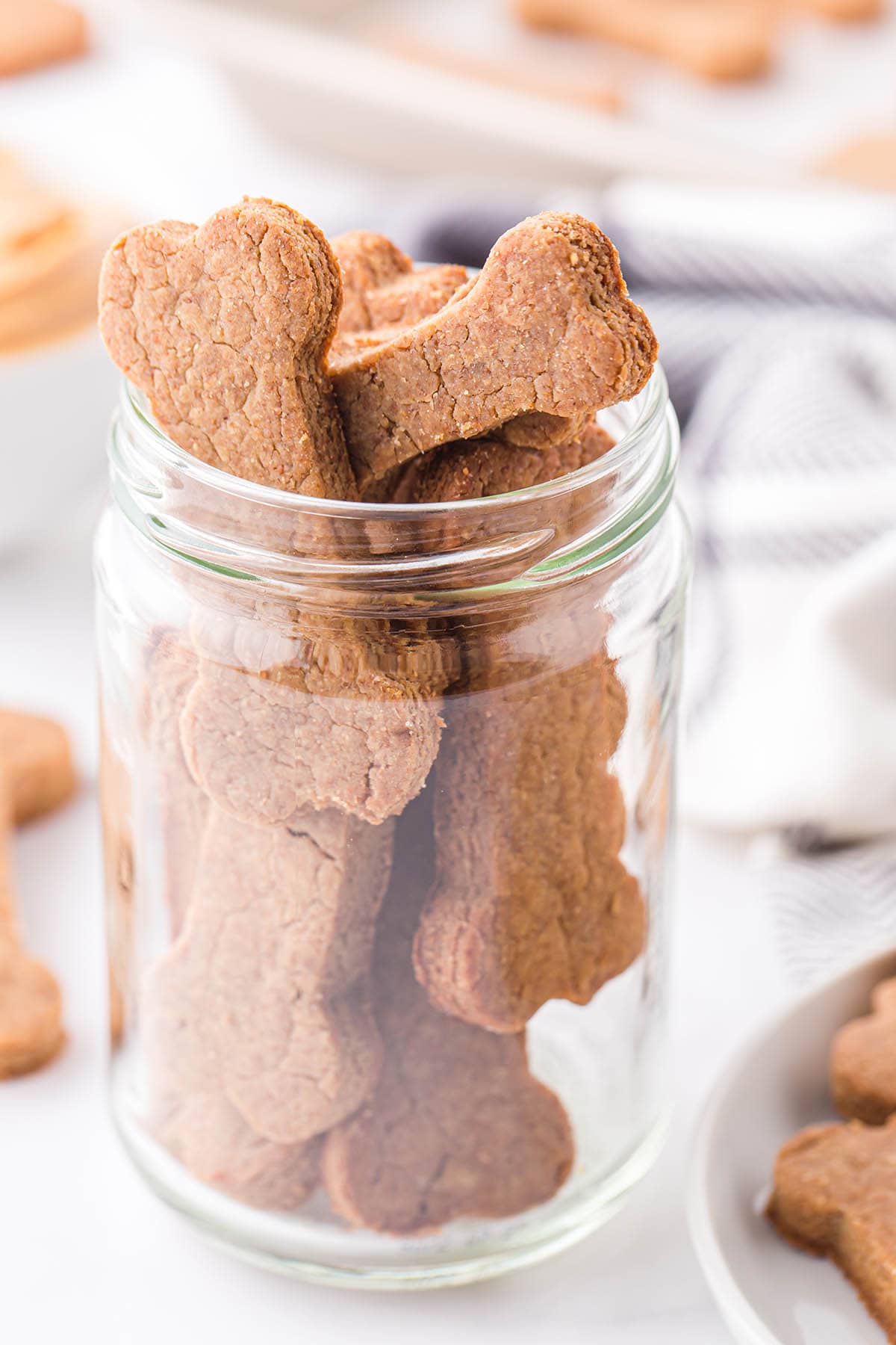 a jar filled with Peanut Butter Dog Treats on the table.